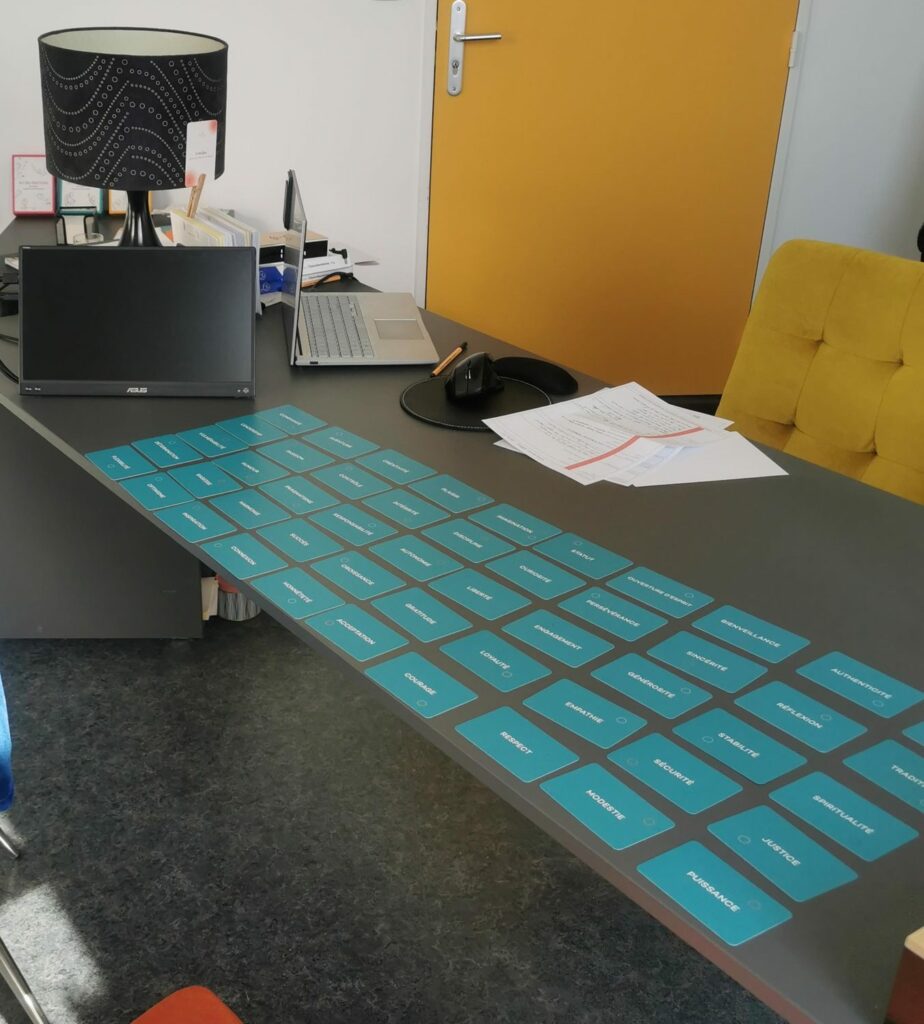 Cartes de valeurs bleues étalées sur le bureau du cabinet, utilisées pendant les séances d’orientation